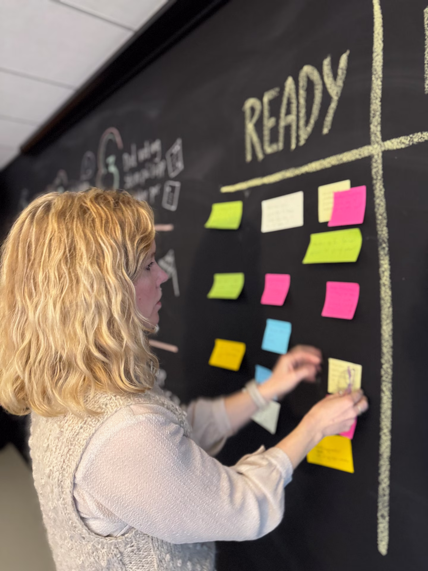 Mari fester 'post-it'-lapper på veggen